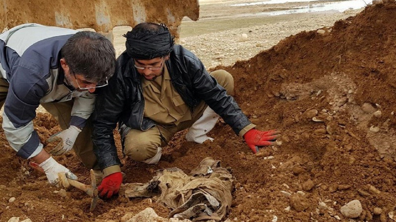 تفحص پیکر یک شهید همراه با نوشتۀ «مرگ بر آمریکا»